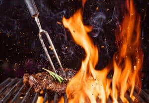 Steak on a tuff grill with flames