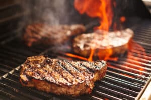 meat on commercial wood charbroiler